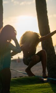 unrecognizable woman walking on rope in sunny park